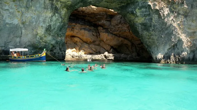 people swimming in water near a boat