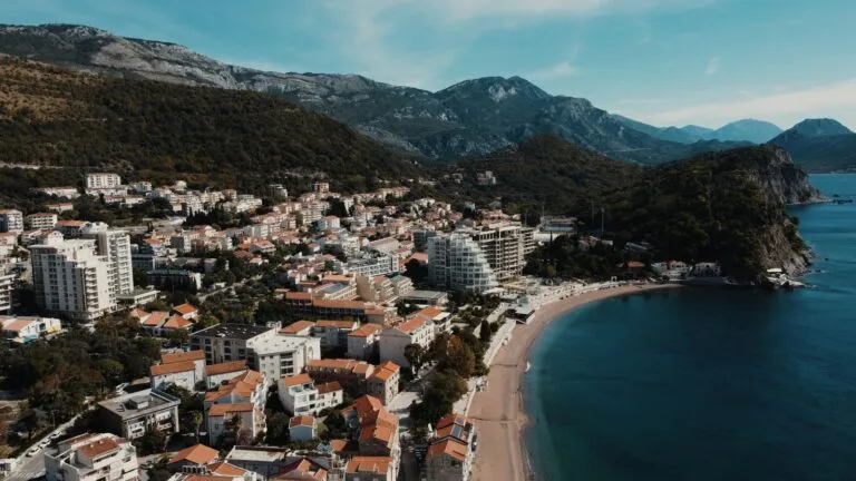 Zachwycający widok z lotu ptaka na Petrovac, Czarnogóra, ukazujący plażę i otaczające góry.
